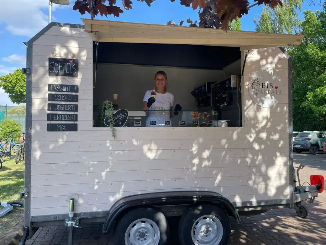 EIS AFFAIR — Softeis-Wagen mit Service am Verkaufsfenster bei einem Event in Niedersachsen